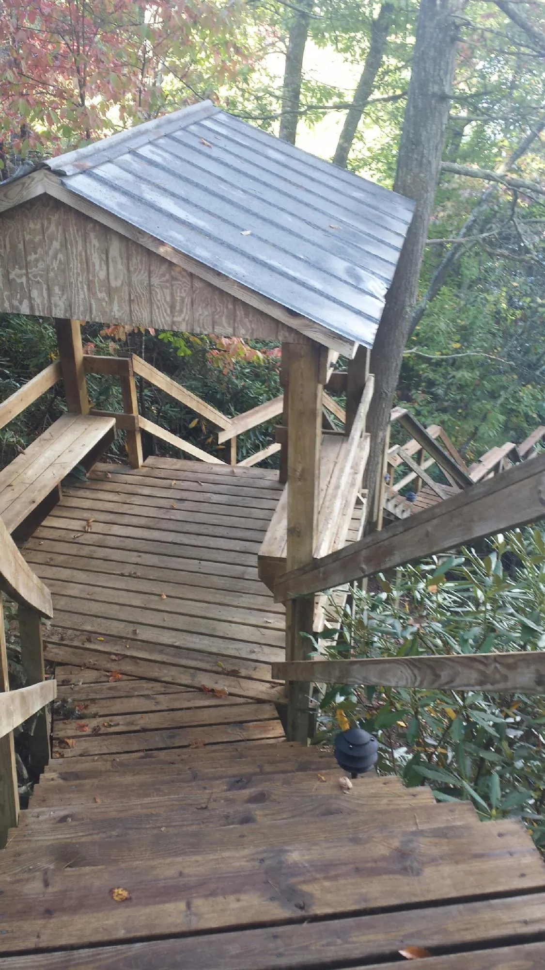 Metal roofed shelter over wooden steps on a wooded walkway — Skylight Repair & Installation work by our crew in Dobbs Ferry