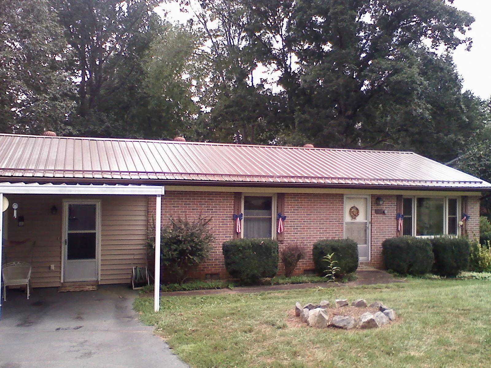Bronze metal roof and carport on a brick ranch home — Roof Repair work by our crew in Dobbs Ferry